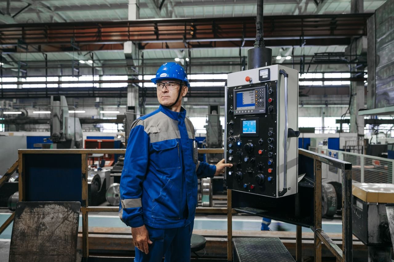 why-choose-us Male factory worker in protective gear operates machinery indoors.