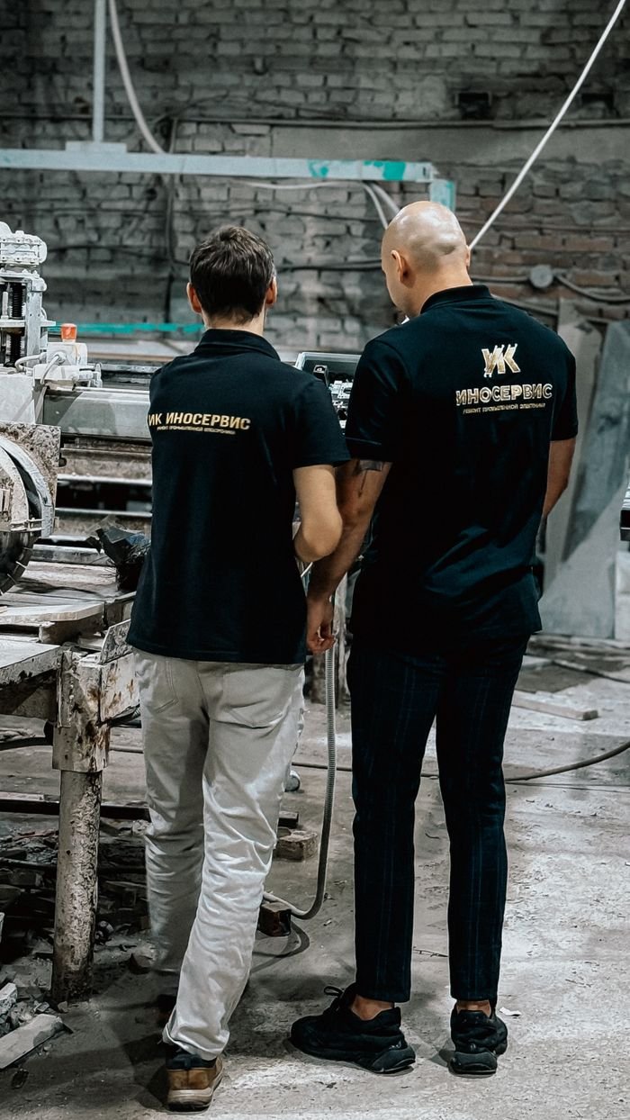 Crafting Captivating Headlines: Your awesome post title goes here Two male workers in company uniforms at an industrial facility, sharing insights and collaboration.